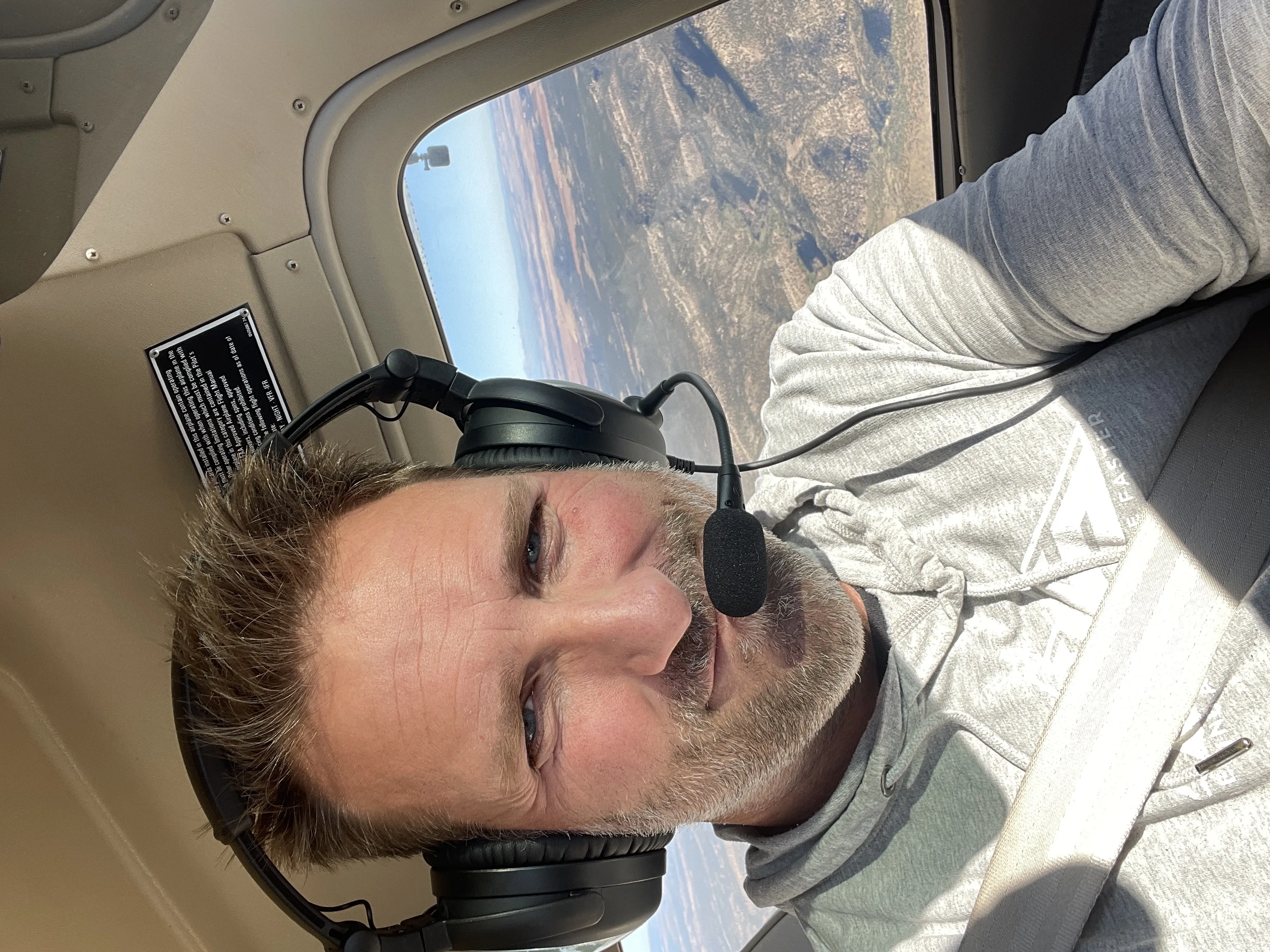 Jason in the cockpit of a small plane wearing a pilot headset